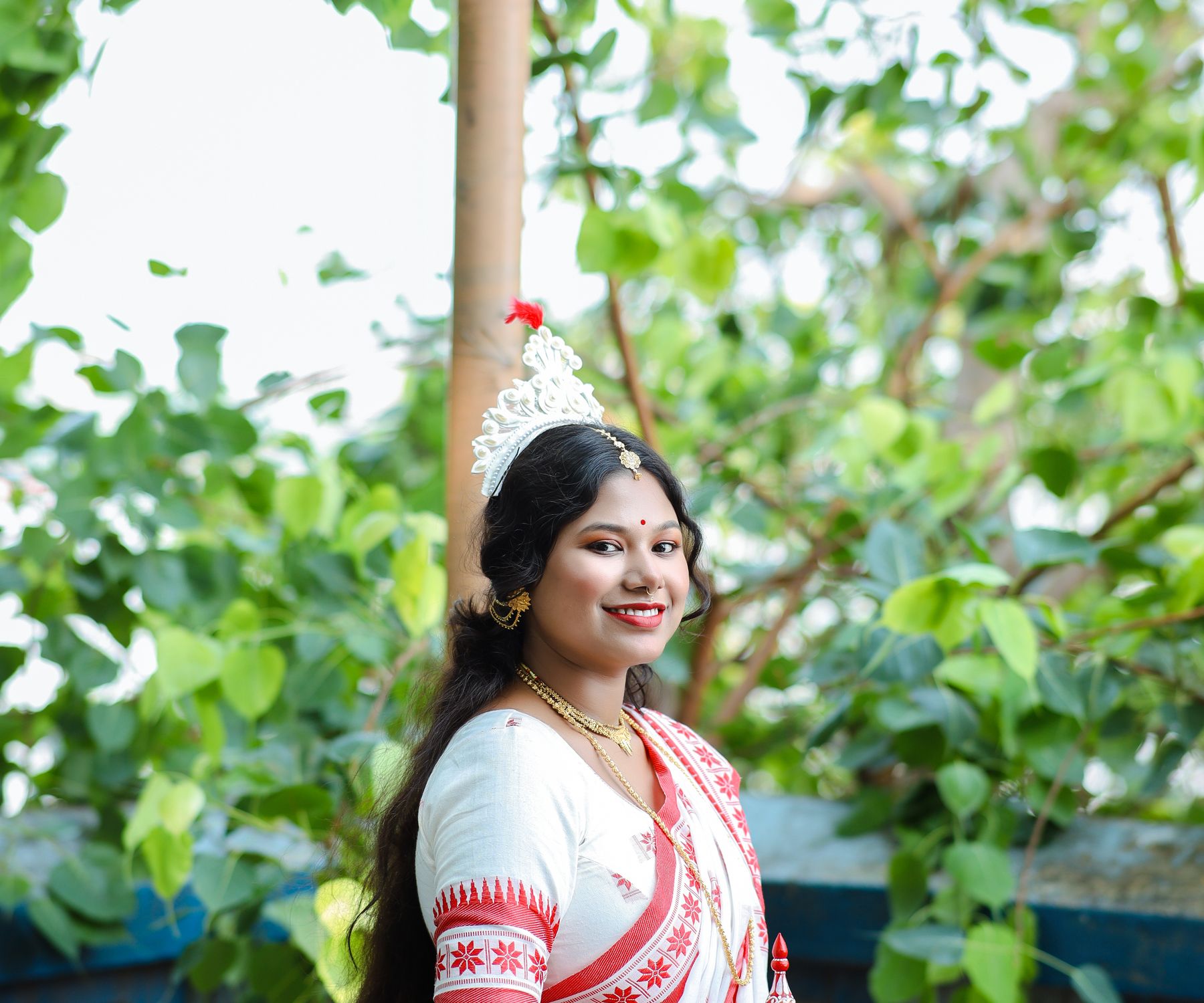 Woman wearing a red and white Assamese mekhela chador